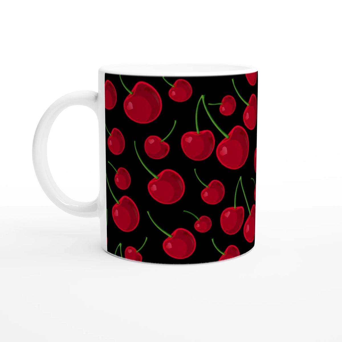 White ceramic coffee mug featuring a retro pattern of bright red cherries with green stems on a black background.