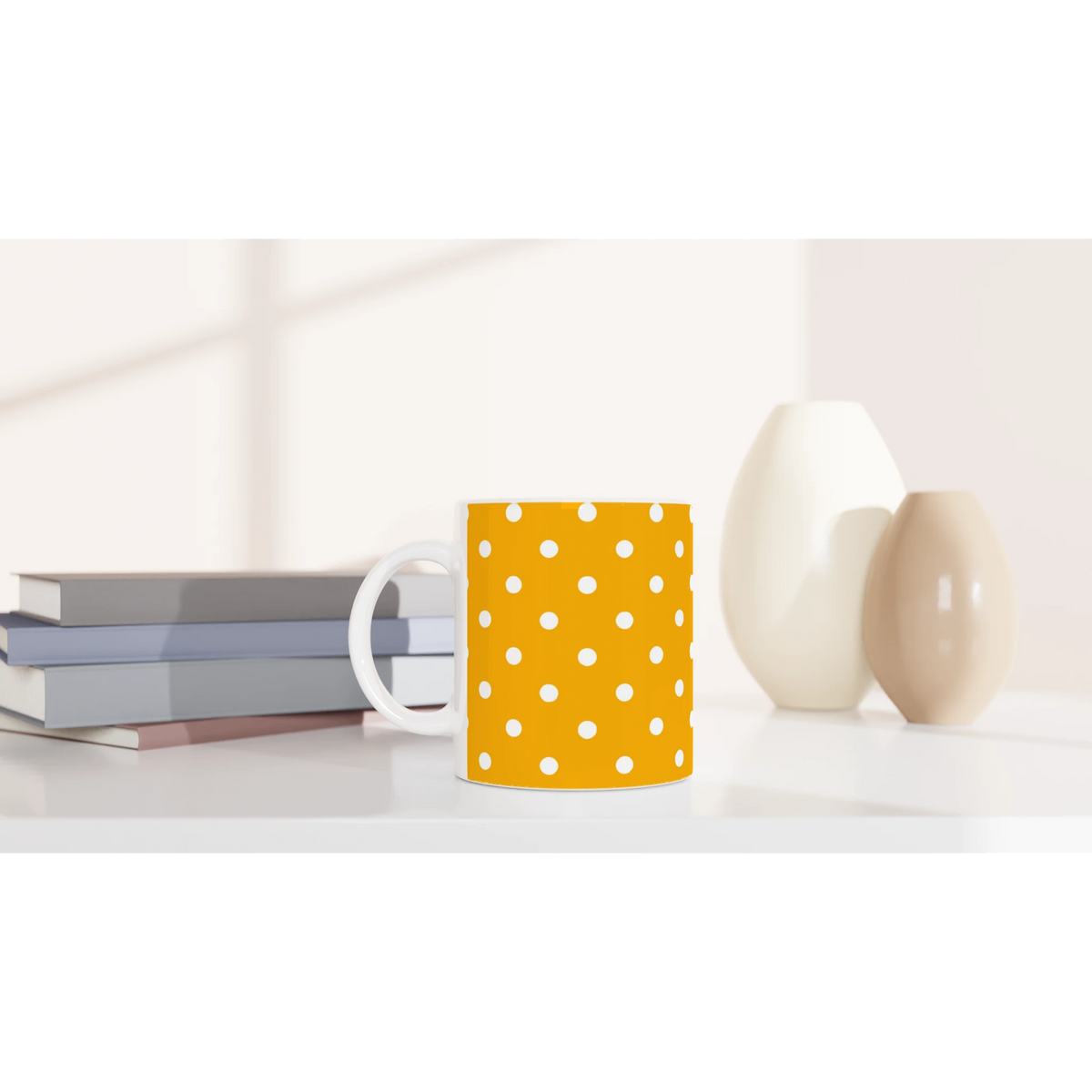 Orange and white polka dot ceramic mug on a desk next to books and vases. Cute spotty coffee cup for daily brews.