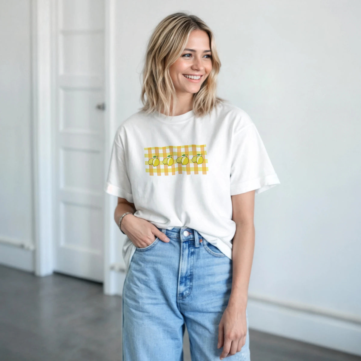 Smiling woman wearing a white t-shirt with a yellow lemon gingham print.
