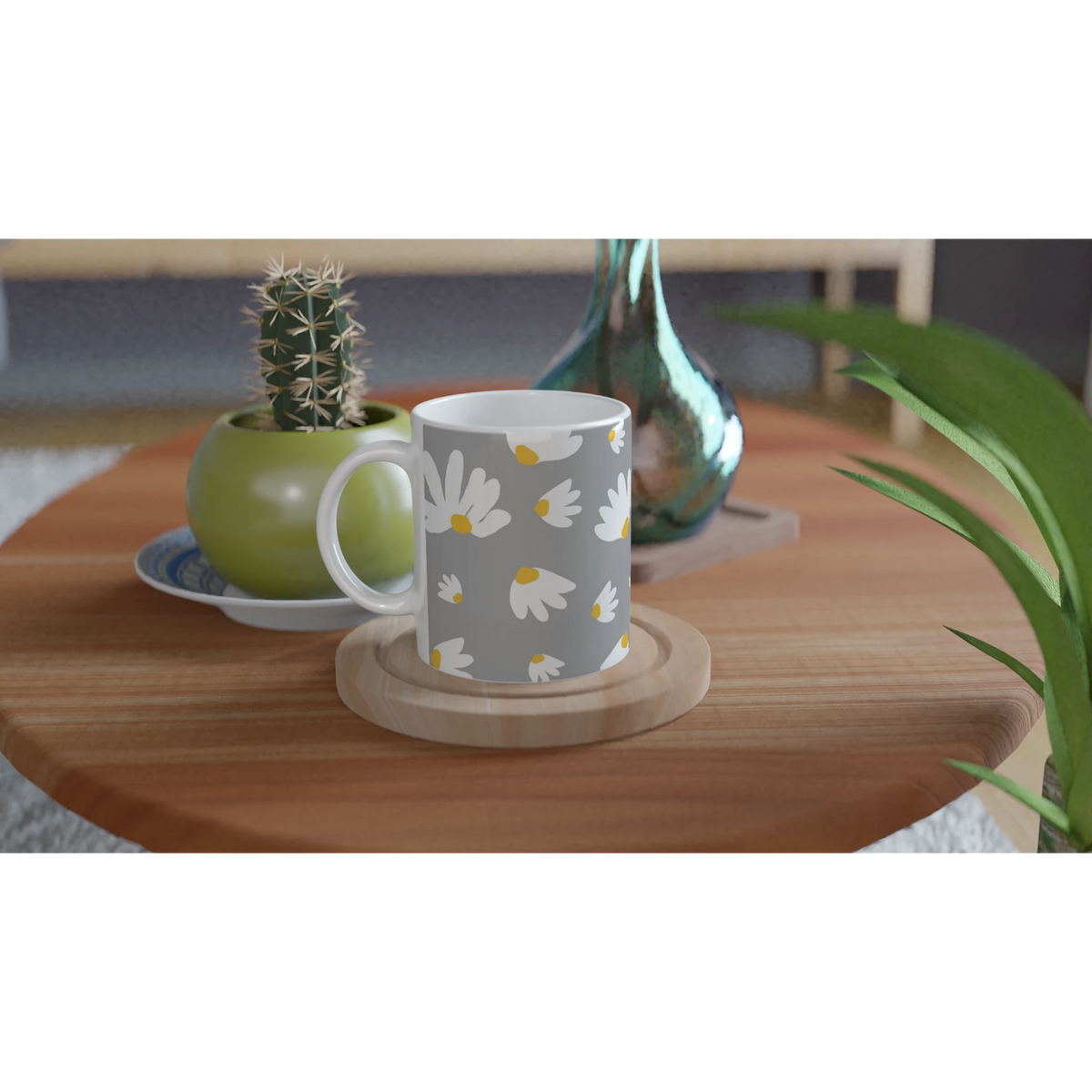 Ditsy Daisy mug with white flowers and yellow centers on gray, set on a wooden table beside a cactus.