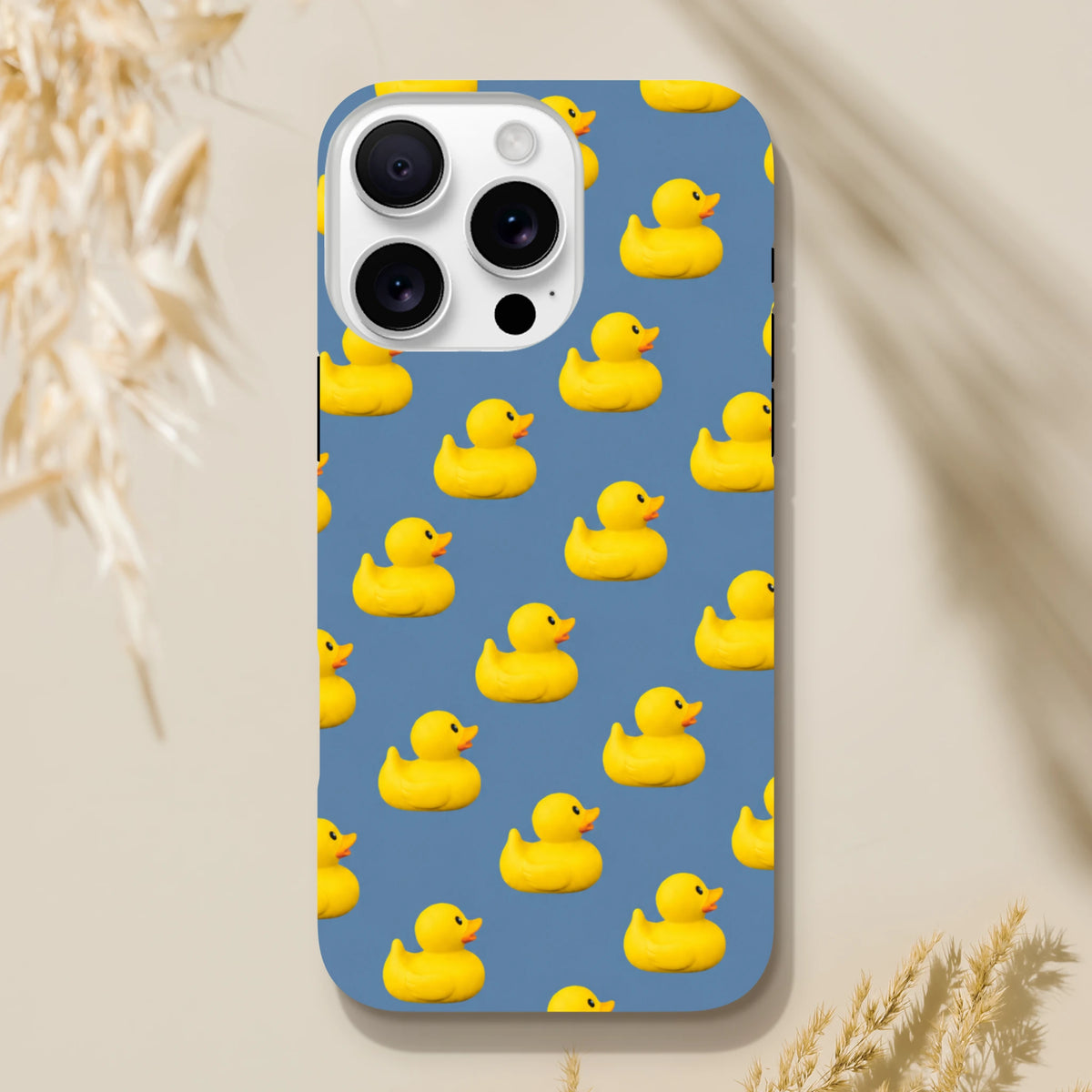 Blue iPhone case featuring a playful pattern of yellow kawaii rubber ducks for a cute and tough streetwear look.