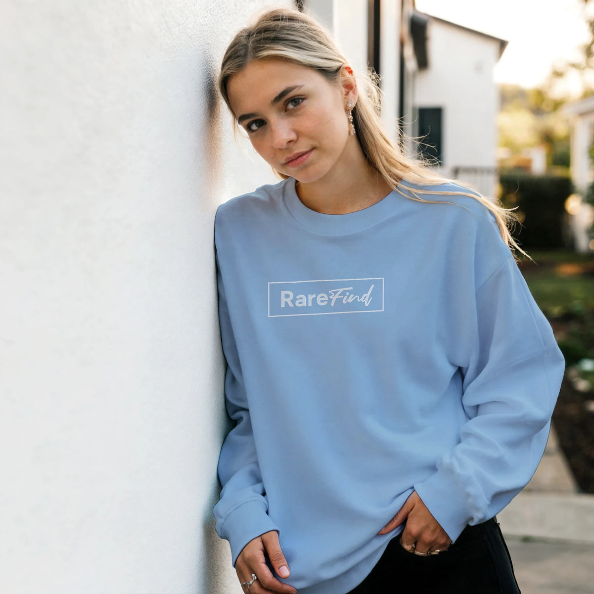 Woman wearing Cute Rare Find Sweatshirt with cozy slogan on light-blue top, casual streetwear vibe.
