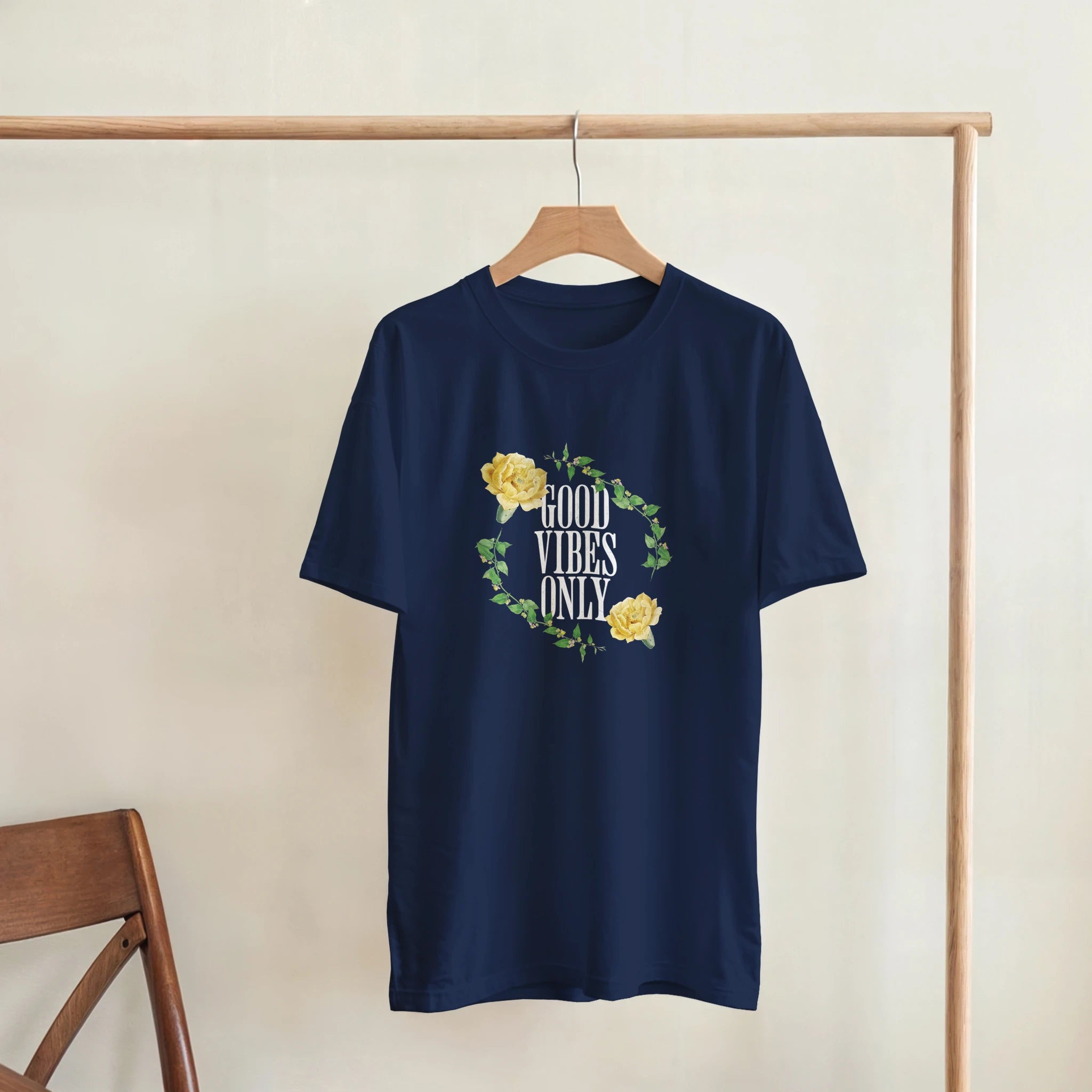 Navy blue men's graphic tee with a circular floral wreath and yellow roses surrounding the words GOOD VIBES ONLY.