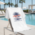 White t-shirt with 'California Los Angeles Tropical State of Mind' design on a lounge chair by a pool.