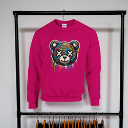 Pink sweatshirt with a colorful bear graphic on a rack against a white wall.
