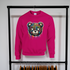 Pink sweatshirt with a colorful bear graphic on a rack against a white wall.