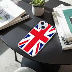 Phone case with British flag design on a black table with books and a plant.