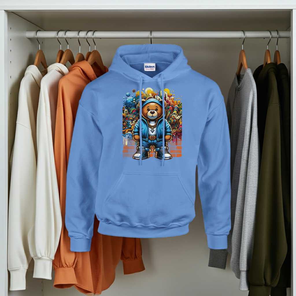 Blue hoodie with a colorful bear design hanging on a rack among other sweaters.