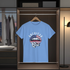 Blue t-shirt with 'American Girl' design hanging in a wardrobe.