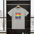 Gray t-shirt with 'Peace & Pride' design on a hanger in front of a window.