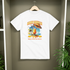White t-shirt with a colorful graphic design hanging on a wooden hanger against a neutral wall.