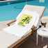 White t-shirt with lemon nutrition graphic on a lounge chair by a pool