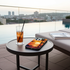 Phone with a sunset case on a table by a poolside with a cityscape view