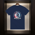 Navy blue t-shirt with 'Independence Day America 4th July' design on a wooden hanger.