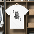 White t-shirt with a skull king design hanging on a wooden rack.