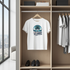 White t-shirt with 'Summer Beach' design hanging in a wardrobe with shoes below.
