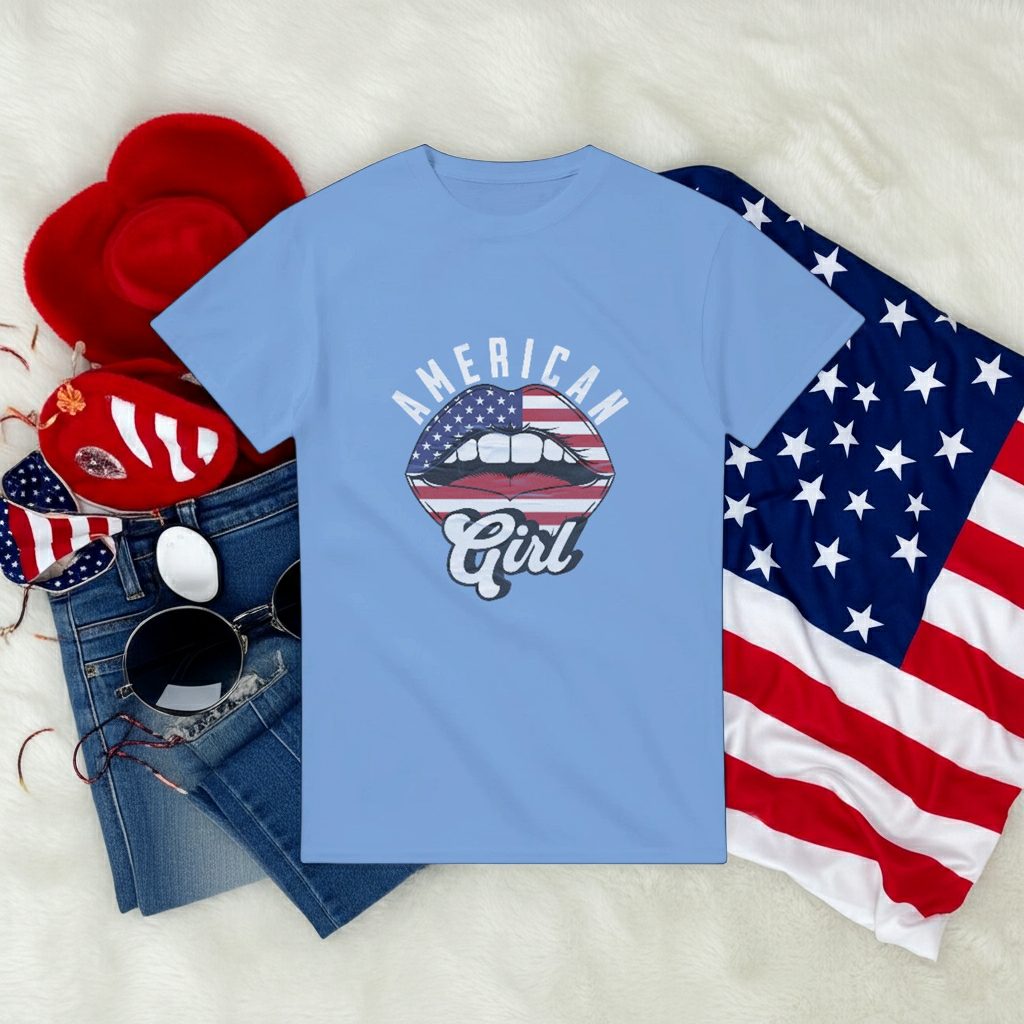 Blue t-shirt with 'American Girl' design, sunglasses, denim jeans, and American flag on a white background