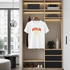 White t-shirt with 'BERLIN' print on a hanger inside a modern wardrobe.
