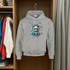Gray hoodie with panda design on a hanger in a wardrobe.