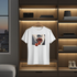 White t-shirt with a graphic design of lips and cherries hanging on a wooden shelf.