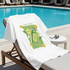 White T-Shirt with a green graphic of a lemonade bottle on a lounge chair by a pool.