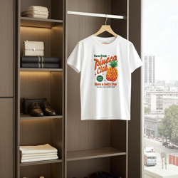 White t-shirt with pineapple graphic and text hanging in a wardrobe.