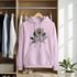 Pink hoodie with floral design and 'You Matter' text hanging in a wardrobe.