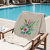 Beige T-Shirt with tropical floral design and 'Paradise' text on a lounge chair by a pool.