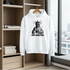 White hoodie with a graphic design on a hanger in a room with a window view.
