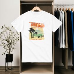 White t-shirt with 'Tropical Dreamer' design hanging in a wardrobe.
