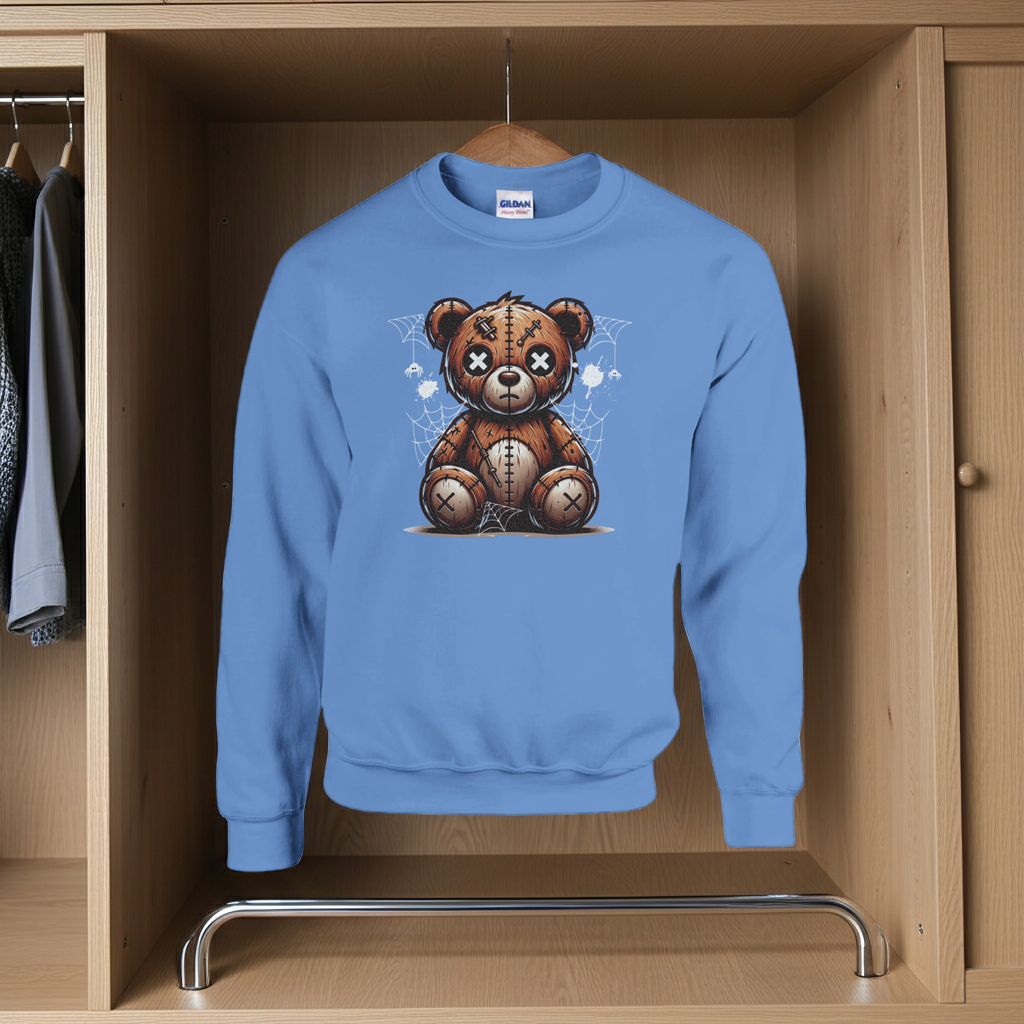 Blue sweatshirt with a teddy bear graphic hanging in a wooden wardrobe.