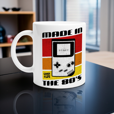 White ceramic mug with retro 80s Game Boy design, bold colors, screen, D-pad, and THE 80S text.