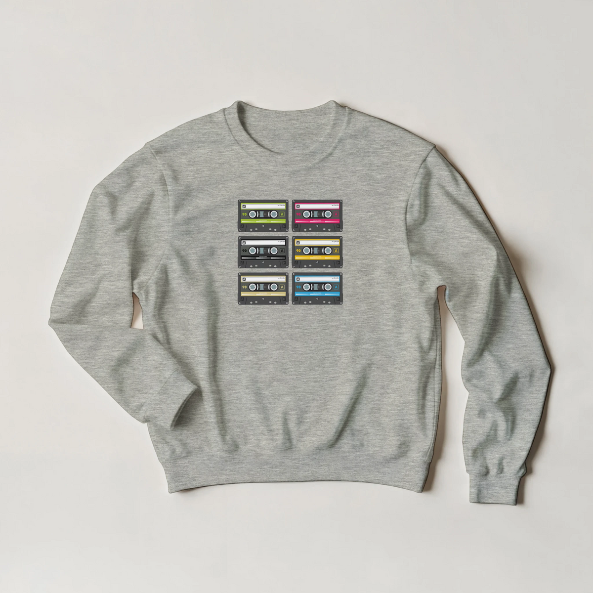 Grey crewneck sweatshirt featuring a vintage 90s cassette tape graphic in six colorful layouts for retro streetwear style.