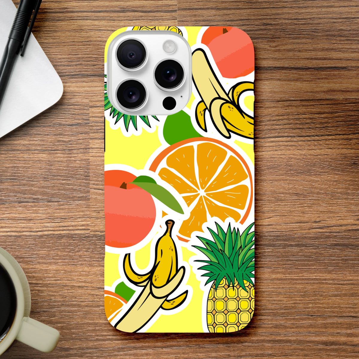 Yellow iPhone case with bold sticker effect graphics featuring bananas, oranges, and pineapple on a vibrant background.