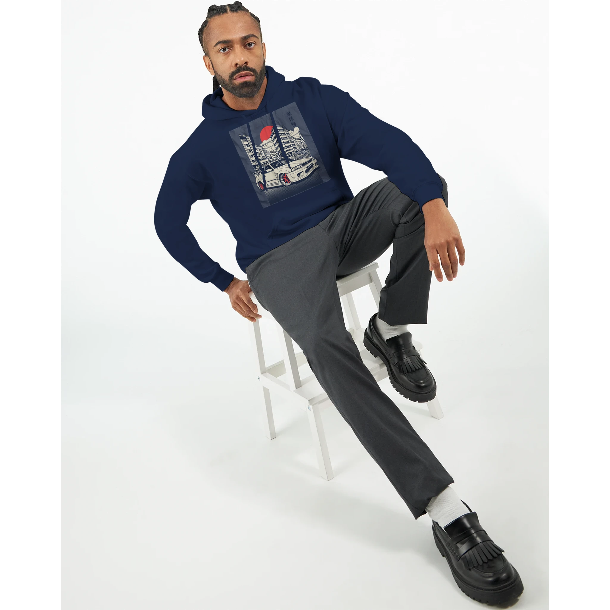 Man wearing navy Car Jumper JDM Hoodie with urban car print, seated on a stool.