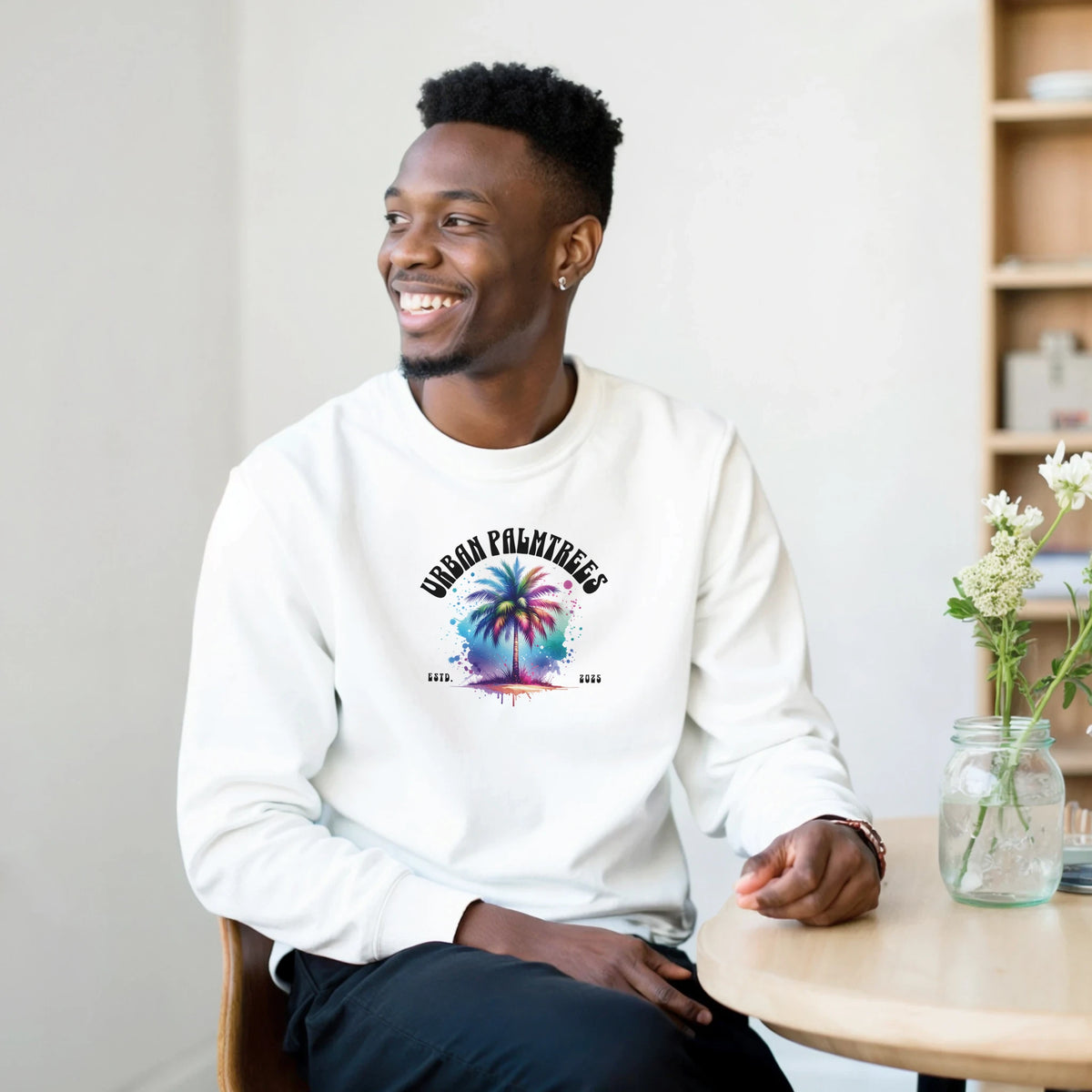 Smiling man wearing a white Urban Palm Trees Sweatshirt with a colorful palm tree graphic
