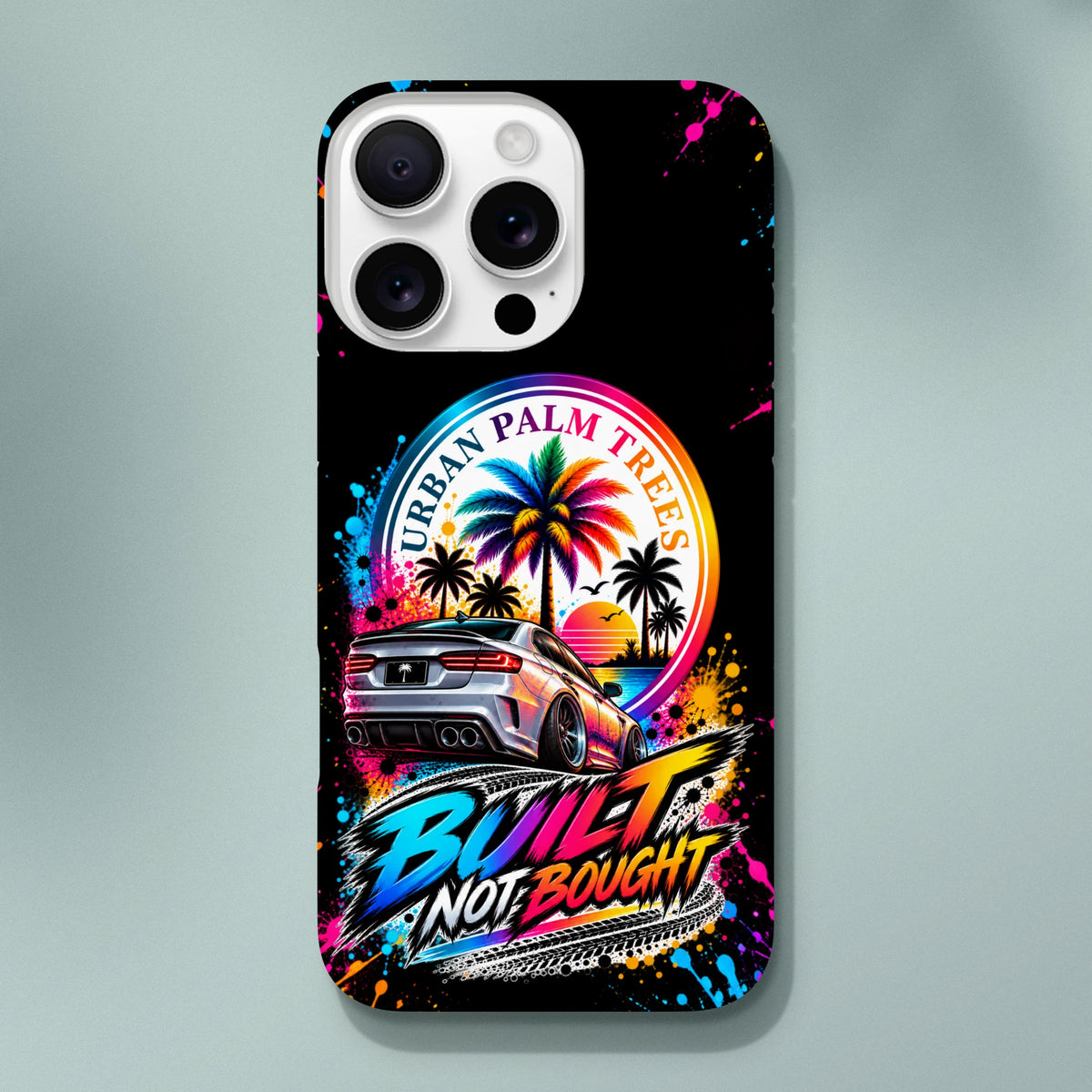 Built Not Bought iPhone case featuring a modified car, colorful palm trees, and Urban Palm Trees text on a splatter background.