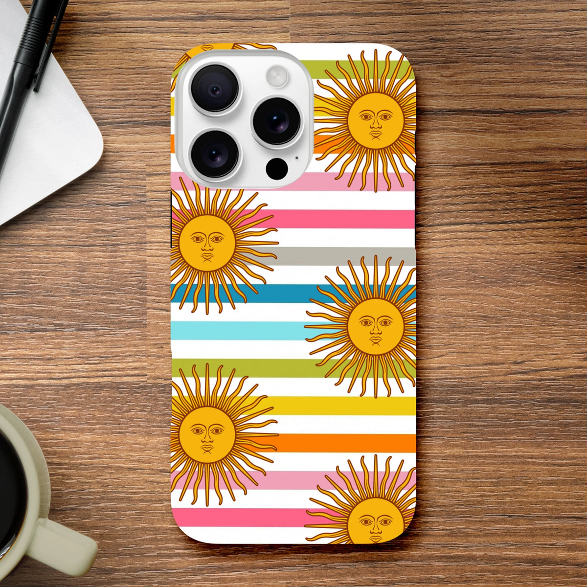 Retro sun stripe iPhone case featuring celestial sun faces with colorful horizontal stripes on a wooden desk.