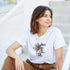 Woman in white cotton-blend Palm Tree graphic T-shirt with palm illustration, casual sunny-day look.