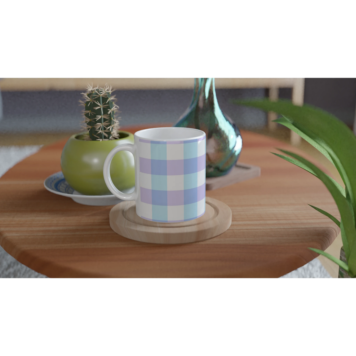 Pastel blue gingham ceramic mug on a wooden table with a small cactus and a green vase nearby.