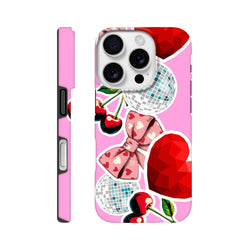 Pink iPhone case with sticker effect design featuring cherries, disco balls, heart bow, and red gem graphics on glossy background.