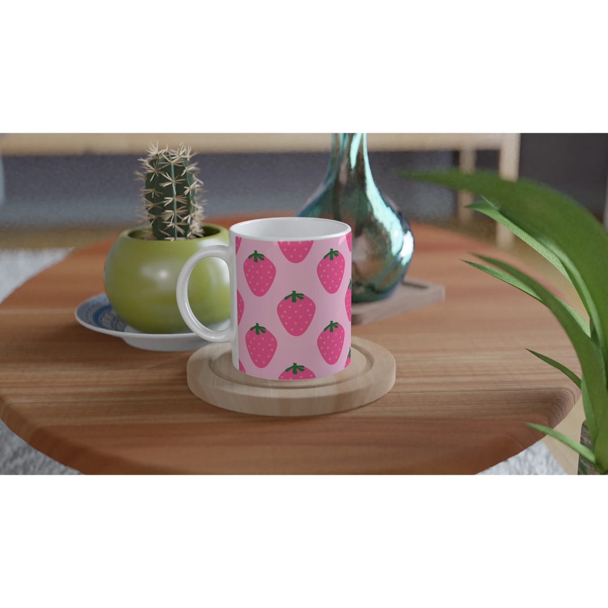 Cute pink strawberry mug with kawaii fruit pattern on a wooden table near a cactus.