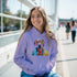 Young woman in lavender Gent Dog Jumper hoodie featuring a colorful dog graphic with glasses and a front pocket.