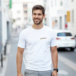Man wearing white San Francisco graphic T-shirt with Golden Gate Bridge design in an urban street.