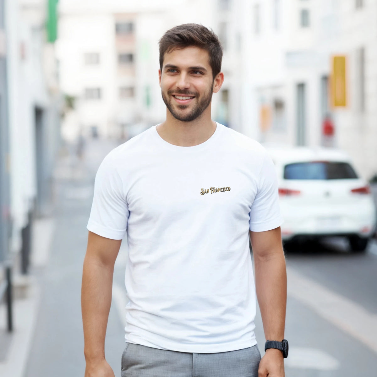 Man wearing white San Francisco graphic T-shirt with Golden Gate Bridge design in an urban street.