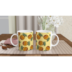 Three yellow pineapple-pattern mugs with white handles on a checkered table, tropical fruit coffee cups.