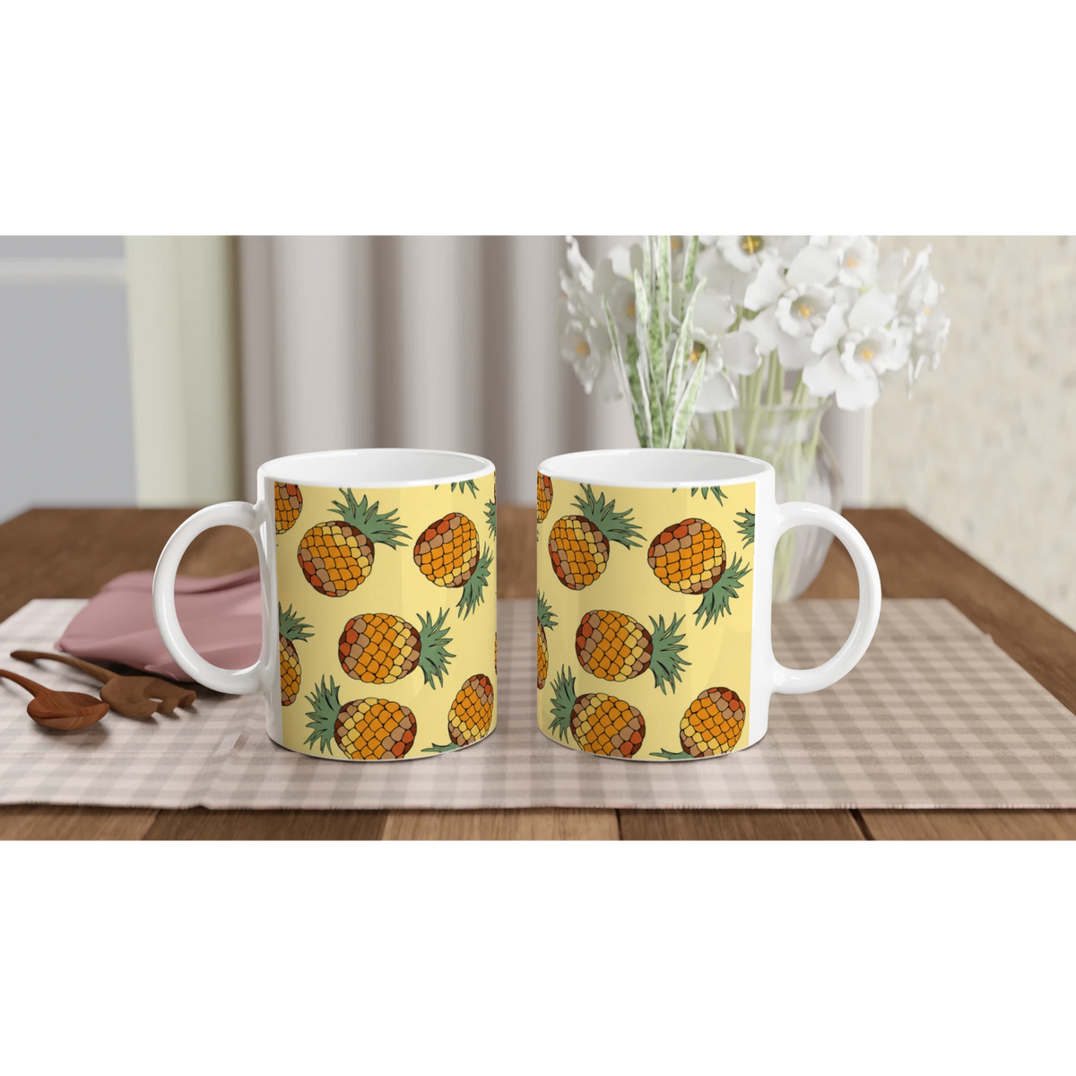 Three yellow pineapple-pattern mugs with white handles on a checkered table, tropical fruit coffee cups.