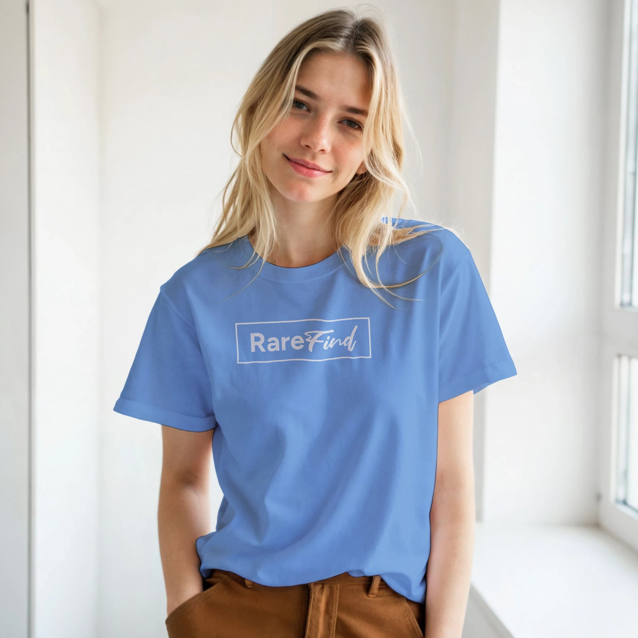 Woman in a blue T-shirt featuring a white RareFind logo, casual urban streetwear.