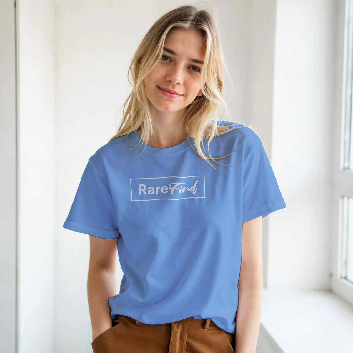 Woman in a blue T-shirt featuring a white RareFind logo, casual urban streetwear.