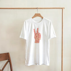 White tee featuring retro pink peace sign hand graphic composed of vintage typography like peace and stop war.